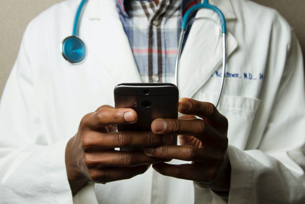 Doctor with smartphone. looking at his own ads?