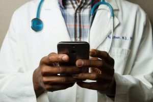 Doctor with smartphone. looking at his own ads?