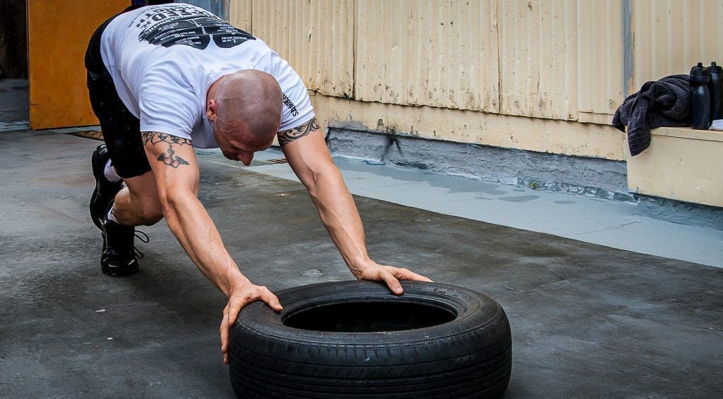 man pushing a tyre fitness